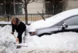 Ciudadano tratando de liberar su vehículo sepultado por la nieve