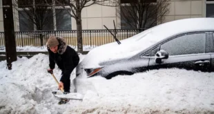 Ciudadano tratando de liberar su vehículo sepultado por la nieve