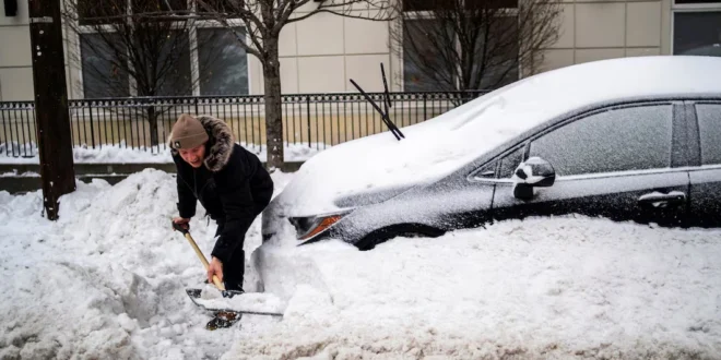 Ciudadano tratando de liberar su vehículo sepultado por la nieve