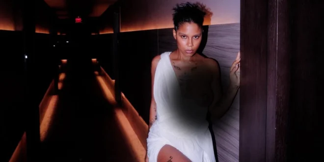 La artista dominicana Tokischa posando en Premio Lo Nuestro 2026 con un vestido blanco conceptual.