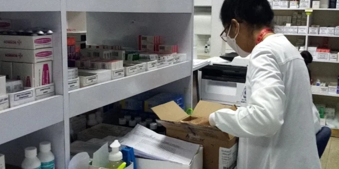 Personal de la Caja de Seguro Social supervisando el inventario de medicamentos en un almacén logístico