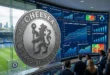 Escudo del Chelsea FC en Stamford Bridge con gráficos financieros de fondo