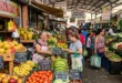 Mercado local con letreros de precios actualizados de frutas y verduras