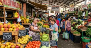 Mercado local con letreros de precios actualizados de frutas y verduras