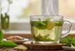 Taza de té verde humeante con hojas naturales destacando sus propiedades saludables