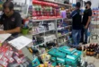 Inspectores de ACODECO verificando precios y fechas de vencimiento en un comercio local