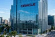 Logotipo de Oracle en un edificio moderno de cristal con fachada azul reflectante