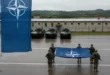 Soldados y bandera de la OTAN en una base militar europea
