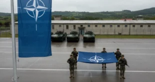 Soldados y bandera de la OTAN en una base militar europea