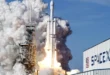 Cohete Falcon 9 de SpaceX despegando hacia el espacio exterior con el logotipo de la empresa en primer plano