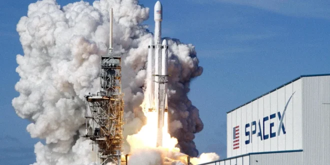 Cohete Falcon 9 de SpaceX despegando hacia el espacio exterior con el logotipo de la empresa en primer plano