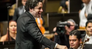 Gustavo Dudamel dirigiendo una orquesta en un escenario internacional