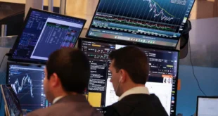 Operadores financieros analizando gráficos de cotizaciones de Wall Street en pantallas gigantes durante una sesión de alta volatilidad